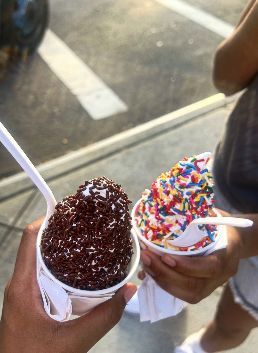 "Two girls holding their ice cream. '